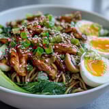 Healthy Miso Chicken Noodle Bowls topped with halved soft-boiled eggs and sesame seeds, ready to enjoy.