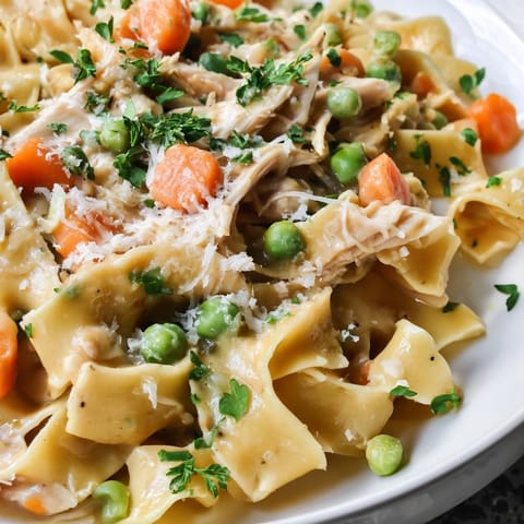 Vibrant spring vegetables and savory chicken mingle in a light cream sauce, served steaming in a skillet for a comforting family dinner.  
