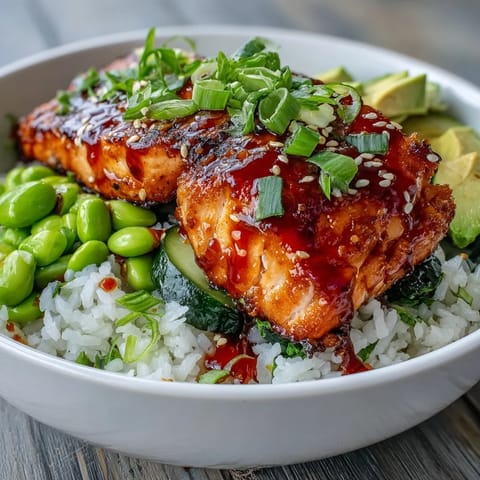 Bowl of honey sriracha salmon topped with creamy avocado, edamame, and a drizzle of spicy sriracha mayo.