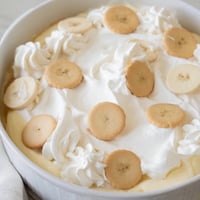 A layered view of creamy, sweet banana pudding, boasting banana slices and vanilla wafers.