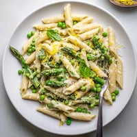 Garlic Parmesan Spring Vegetable Pasta with bright green asparagus, peas, and green beans in a creamy sauce.