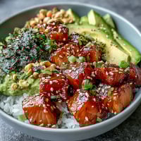 Freshly seared salmon rests on seasoned sushi rice, topped with creamy avocado slices, crisp cucumber, and spring onions in this Avocado Salmon Bowl.