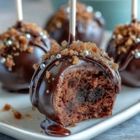 Festive Pot of Gold Cake Pops decorated with edible gold sprinkles and black candy coating, perfect for St. Patrick's Day celebrations.